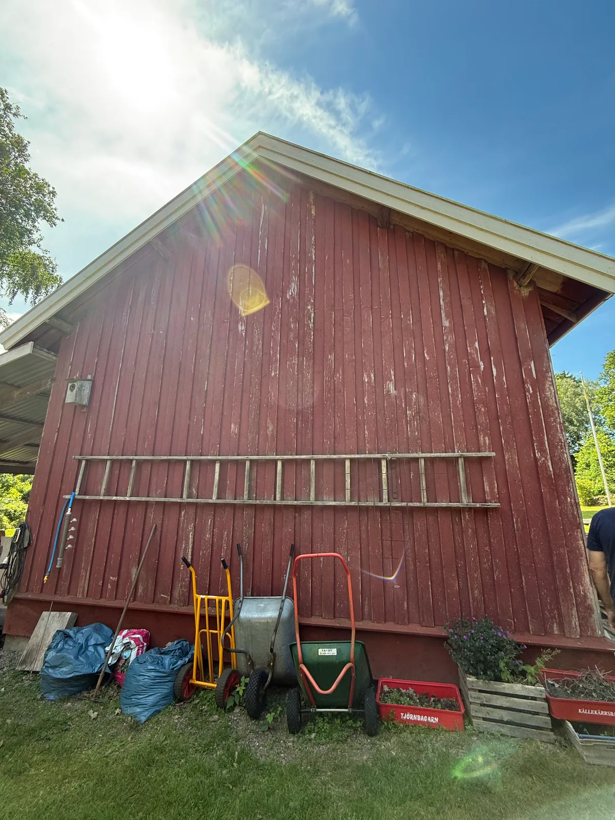 Ekonomibyggnadens gavel före målning, med sliten träpanel.