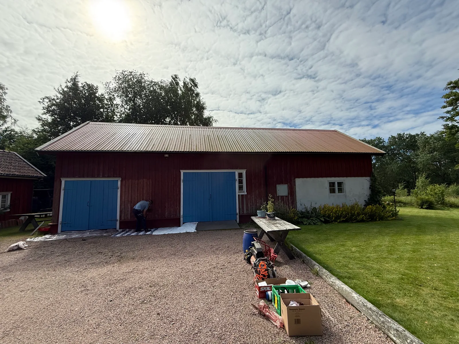 Ekonomibyggnadens långsida före måleri, med blekt och sliten fasad.